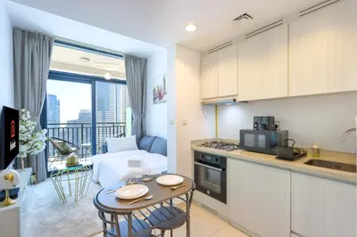 a kitchen and living room with a small table in a room at Canalfront Gem 1BR in Zada Tower by Livbnb in Dubai