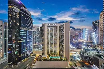 a city skyline at night with tall buildings at Luxury 1BR in Business Bay - Close to Dubai Mall, Burj Khalifa & City Sights in Dubai