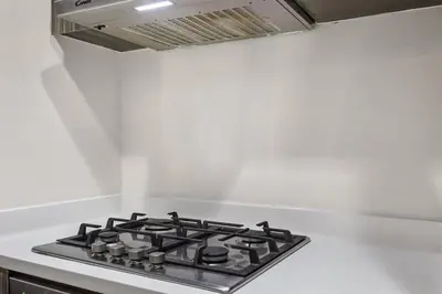 a stove top oven in a white kitchen at Luxury 1BR in Business Bay - Close to Dubai Mall, Burj Khalifa & City Sights in Dubai