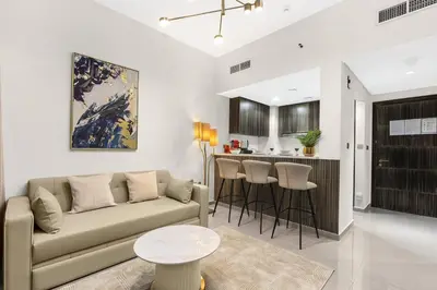 a living room with a couch and a kitchen at Luxury 1BR in Business Bay - Close to Dubai Mall, Burj Khalifa & City Sights in Dubai