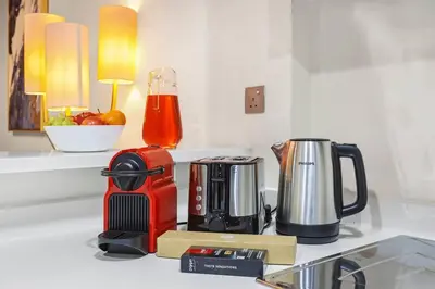 a kitchen counter with a coffee maker on a counter at Luxury 1BR in Business Bay - Close to Dubai Mall, Burj Khalifa & City Sights in Dubai