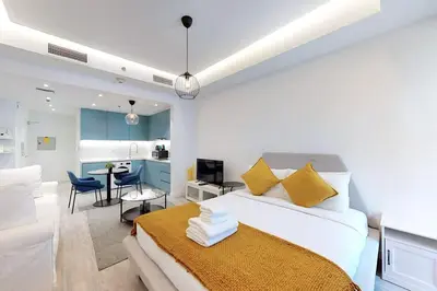 a bedroom with a bed and a living room at Fabulous Studio in JLT with Lake View in Dubai