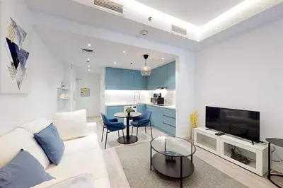 a living room with a white couch and a table at Fabulous Studio in JLT with Lake View in Dubai