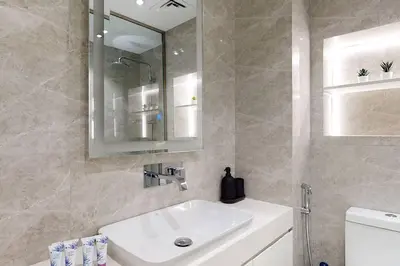 a bathroom with a sink and a mirror and a toilet at Fabulous Studio in JLT with Lake View in Dubai