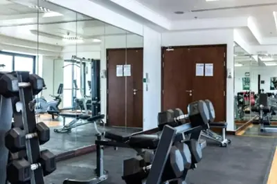 a gym with several treadmills and a mirror at Fabulous Studio in JLT with Lake View in Dubai