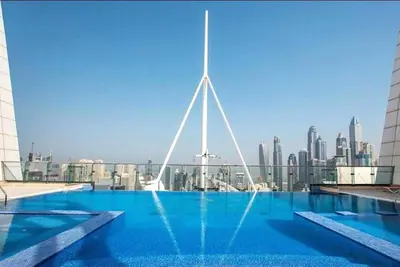 a swimming pool with a city skyline in the background at Fabulous Studio in JLT with Lake View in Dubai