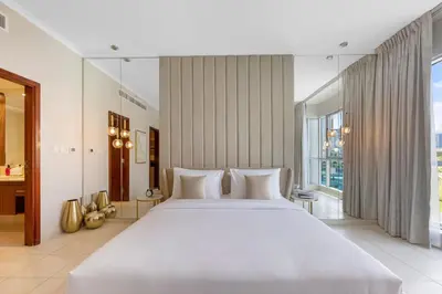 a bedroom with a large white bed and a large window at Durrani Homes - The Luxe 3br with Burj Khalifa and Fountain View - third room without partition in Dubai