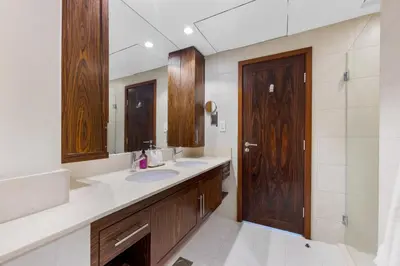 a bathroom with a sink and a wooden door at Durrani Homes - The Luxe 3br with Burj Khalifa and Fountain View - third room without partition in Dubai