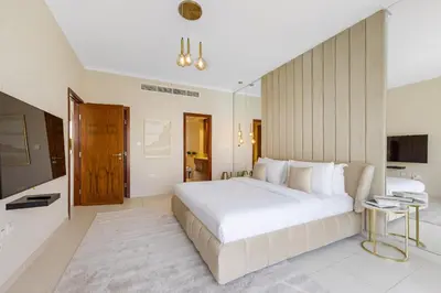 a bedroom with a large white bed and a bathroom at Durrani Homes - The Luxe 3br with Burj Khalifa and Fountain View - third room without partition in Dubai