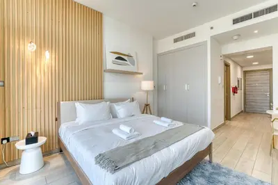 a bedroom with a large bed with two towels on it at Stylish Studio with Pool, Gym & Tasteful Decor in Dubai
