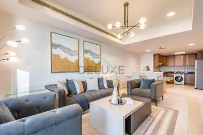 a living room with blue couches and a table at Panoramic 2BR Apartment in Princess Tower, Dubai Marina by Deluxe Holiday Homes in Dubai