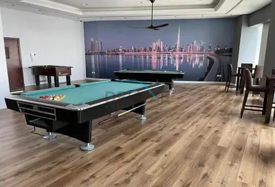 a pool table in a room with a view of a city at Panoramic 2BR Apartment in Princess Tower, Dubai Marina by Deluxe Holiday Homes in Dubai