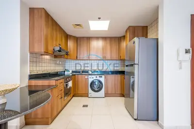 a kitchen with a refrigerator and a washing machine at Panoramic 2BR Apartment in Princess Tower, Dubai Marina by Deluxe Holiday Homes in Dubai