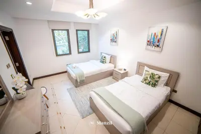 a bedroom with two beds and a ceiling fan at Lux 5BR Villa with Pool & Beach Access in Palm Jumeirah in Dubai