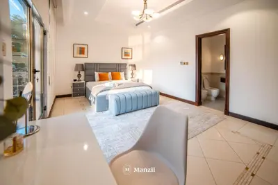 a bedroom with a bed and a bathroom at Lux 5BR Villa with Pool & Beach Access in Palm Jumeirah in Dubai