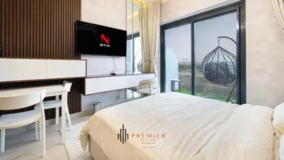 a bedroom with a bed and a desk and a television at PREMIER STUDIO I Poolside in Dubai