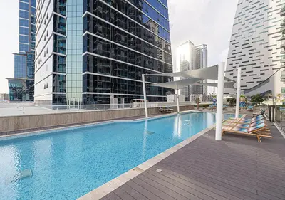 a swimming pool in a city with tall buildings at Brand new Studio in Business Bay, Missoni Tower in Dubai