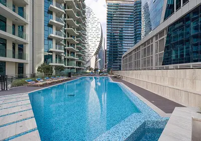a large swimming pool in a city with tall buildings at Brand new Studio in Business Bay, Missoni Tower in Dubai