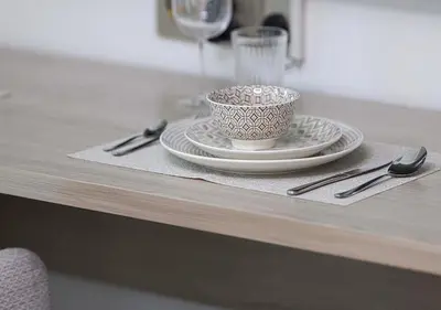 a table with a cup and plates and a glass at Brand new Studio in Business Bay, Missoni Tower in Dubai