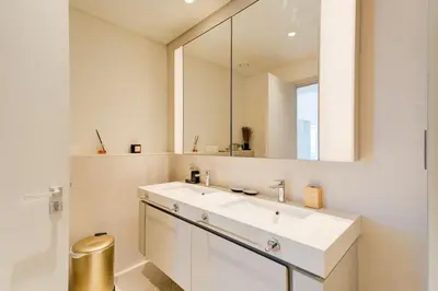 a bathroom with a white sink and a mirror at Private Beachfront 2 Bed With 180 Marina Skyline in Dubai