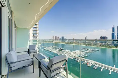 a balcony with chairs and a view of a marina at Private Beachfront 2 Bed With 180 Marina Skyline in Dubai