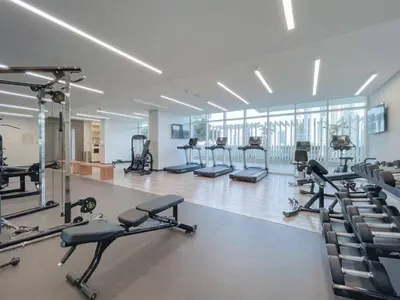 a gym with rows of treadmills and exercise bikes at Private Beachfront 2 Bed With 180 Marina Skyline in Dubai