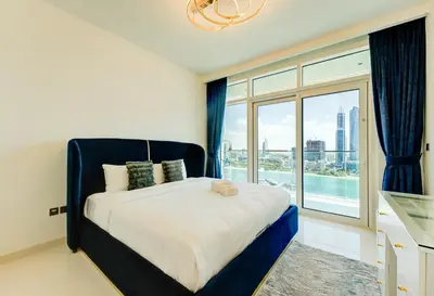 a bedroom with a large bed and a large window at Private Beachfront 2 Bed With 180 Marina Skyline in Dubai