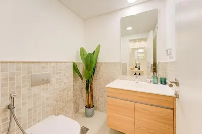 a bathroom with a sink and a toilet and a mirror at Serene 2-Bed Haven in Jumeirah Golf Estates in Dubai