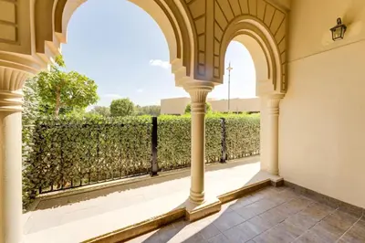 an archway in a building looking out at a hedge at Serene 2-Bed Haven in Jumeirah Golf Estates in Dubai