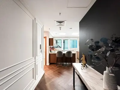 a living room with a table and a kitchen at Trophy Starlight Suites Lux Upgraded 1BR in Marina in Dubai