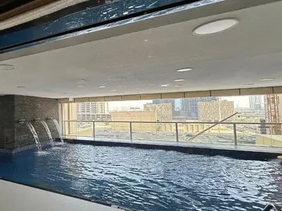 a large swimming pool in a building with a large window at Trophy Starlight Suites Lux Upgraded 1BR in Marina in Dubai