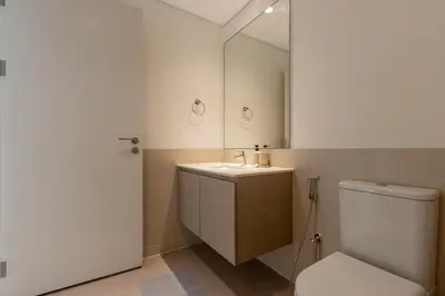 a bathroom with a toilet and a sink and a mirror at Livbnb - Stylish 1B in Park Heights Dubai Hills in Dubai