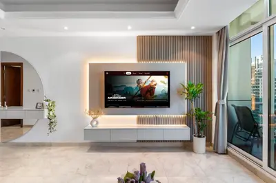 a living room with a flat screen tv on a wall at Elegant One Bed Apartment - Panoramic Marina Views - Near JBR & Beach in Dubai