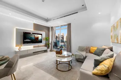 a living room with a couch and a tv at Elegant One Bed Apartment - Panoramic Marina Views - Near JBR & Beach in Dubai