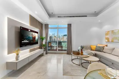 a living room with a couch and a tv at Elegant One Bed Apartment - Panoramic Marina Views - Near JBR & Beach in Dubai