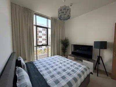 a bedroom with a bed and a large window at Shared Apartment In Dubai Hills in Dubai