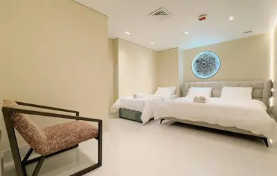 a bedroom with two beds and a chair in it at Usmans 4 Bedroom Apartment on D Beach By SLS DIRECT BEACH ACCESS FULLY SERVICED JBR in Dubai
