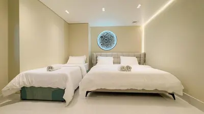 a bedroom with two beds with white sheets at Usmans 4 Bedroom Apartment on D Beach By SLS DIRECT BEACH ACCESS FULLY SERVICED JBR in Dubai