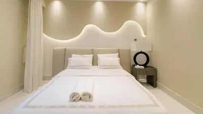 a bedroom with a white bed with two slippers on it at Usmans 4 Bedroom Apartment on D Beach By SLS DIRECT BEACH ACCESS FULLY SERVICED JBR in Dubai