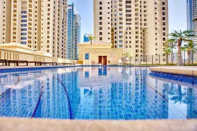 a swimming pool in a city with tall buildings at Bright apartment in JBR few steps from the beach in Dubai