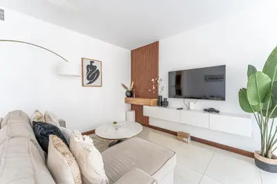 a living room with a couch and a tv at HAVN - 1 Bedroom Apartment in Villa Pera, JVC in Dubai