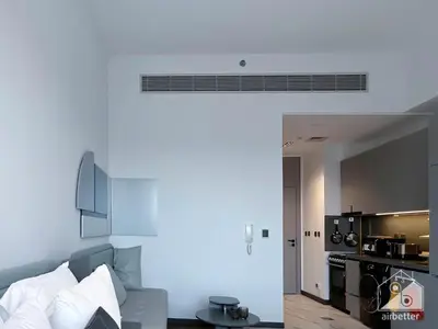 a living room with a couch and a kitchen at Modern Meydan Studio with Private Balcony in Dubai