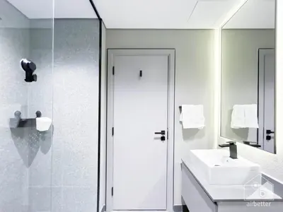 a white bathroom with a sink and a shower at Modern Meydan Studio with Private Balcony in Dubai
