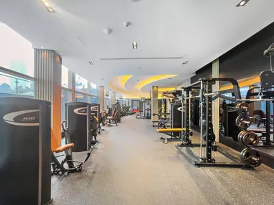 a gym with rows of treadmills and machines at Chic 1BR APT with Pool, Gym, BBQ, Tennis Court in Dubai