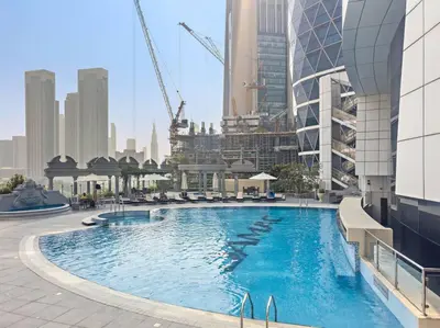 a swimming pool on the side of a building at Chic 1BR APT with Pool, Gym, BBQ, Tennis Court in Dubai