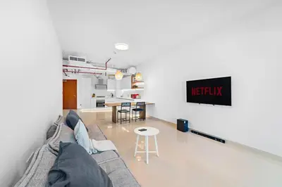 a living room with a couch and a table at Chic 1BR APT with Pool, Gym, BBQ, Tennis Court in Dubai