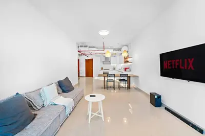 a living room with a couch and a table at Chic 1BR APT with Pool, Gym, BBQ, Tennis Court in Dubai