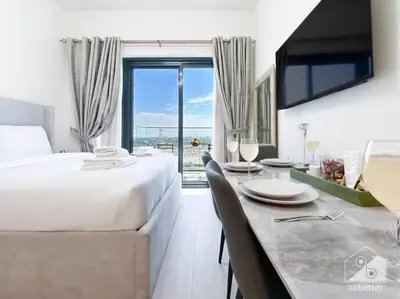 a hotel room with a bed and a table with chairs at Balcony Studio Haven in Riviera in Dubai