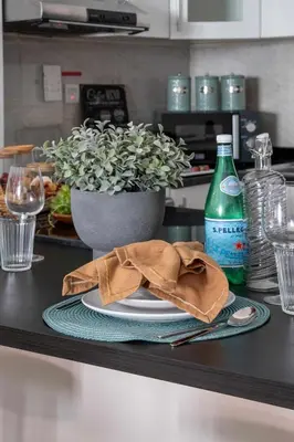 a table with a plate with a napkin and a bottle of soda at Frank Porter - G24 Tower in Dubai
