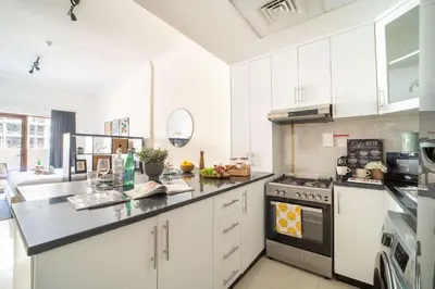 a kitchen with white cabinets and a stove top oven at Frank Porter - G24 Tower in Dubai